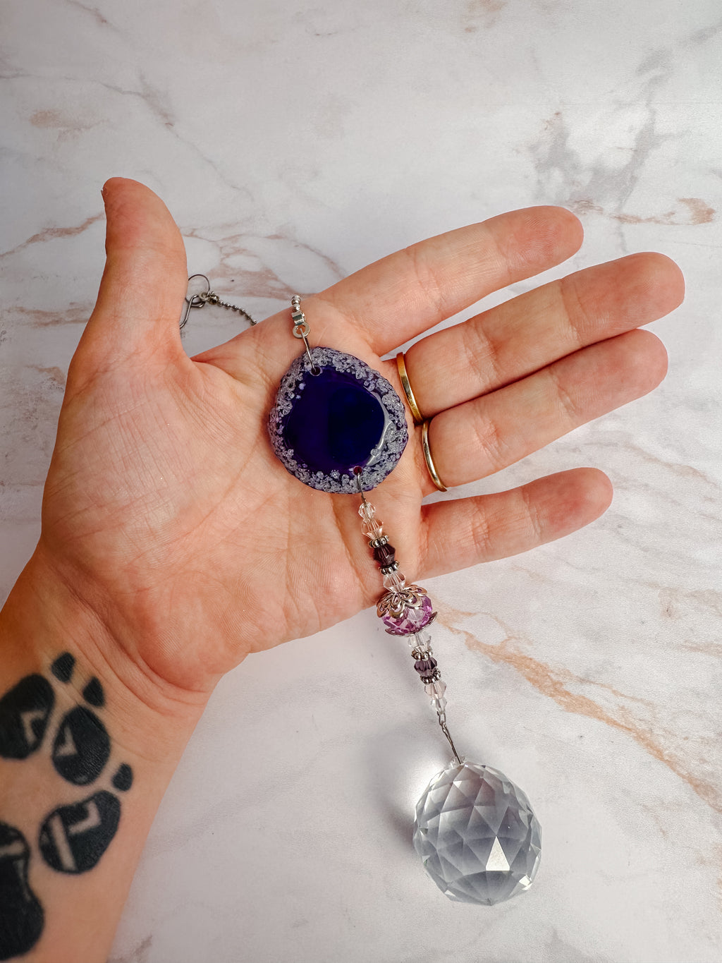 Détail d’un attrape-soleil en agate violette avec perles et cristal