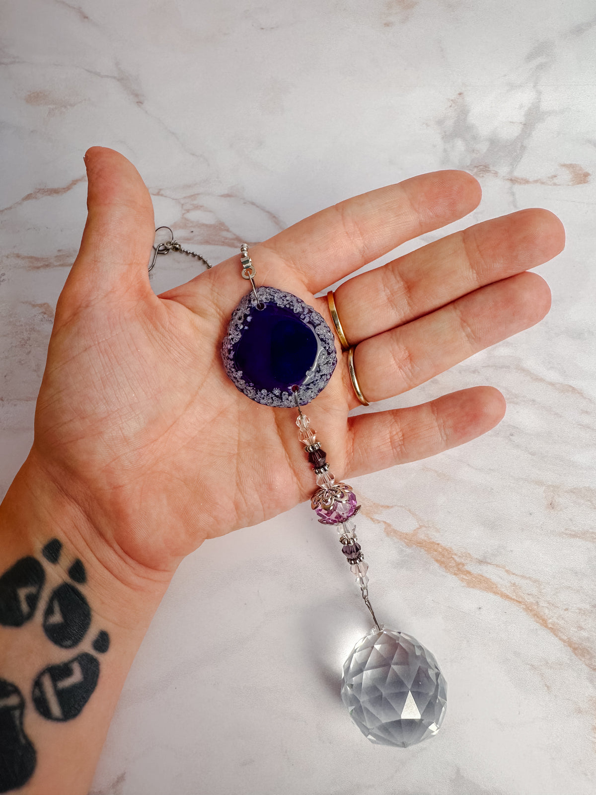 Détail d’un attrape-soleil en agate violette avec perles et cristal